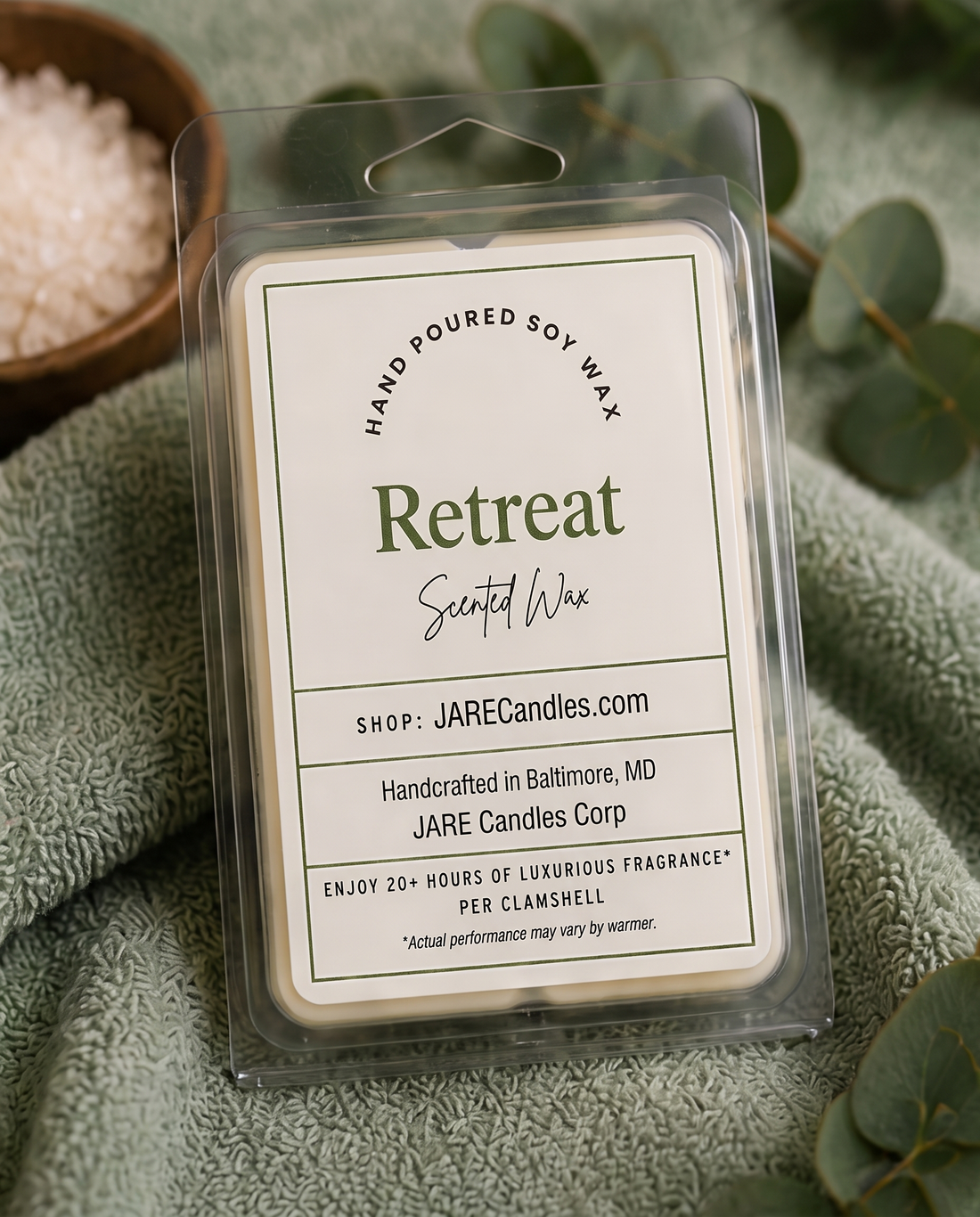 Retreat scented wax melts clamshell with river stones, spa towel and a lit candle
