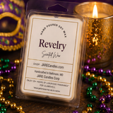 Revelry wax melts clamshell beside a glowing gold mercury glass candle