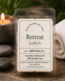 Retreat scented wax melts clamshell with river stones, spa towel and a lit candle