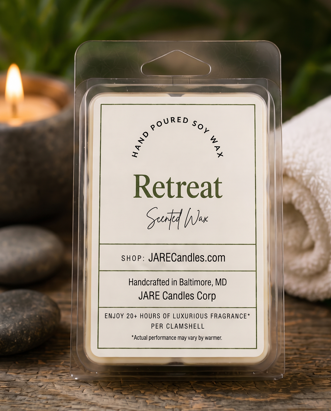 Retreat scented wax melts clamshell with river stones, spa towel and a lit candle