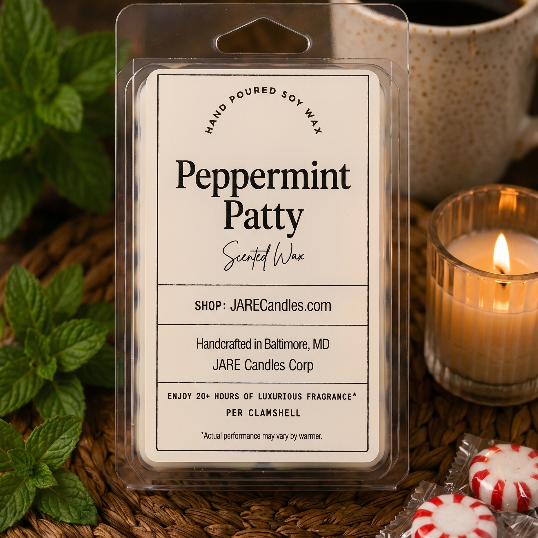 Peppermint Patty wax melts clamshell with mint sprigs and a lit ribbed glass candle