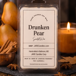 Drunken Pear wax melts clamshell on a slate board with pears, a copper bowl of cinnamon and a lit candle