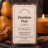 Drunken Pear wax melts clamshell on a slate board with pears, a copper bowl of cinnamon and a lit candle
