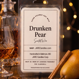 Drunken Pear wax melts clamshell beside a brandy decanter with warm string lights behind