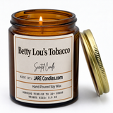 Betty Lou's Tobacco 5oz amber jar candle, lit, lid resting against jar
