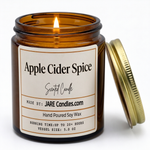 Apple Cider Spice 5oz amber jar candle, lit, lid resting against jar